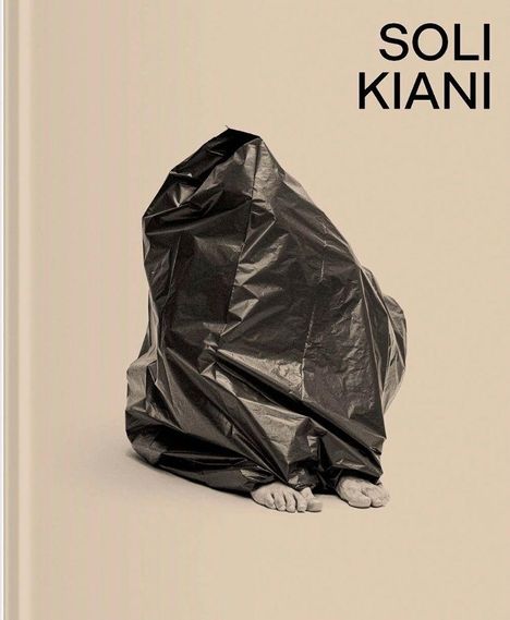 "SOLI KIANI" steht oben. Ein Fuß ragt aus einem schwarzen Plastiksack auf einem hellen Hintergrund hervor.
