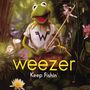 „weezer“ und „Keep Fishin'“ in gelber Schrift. Ein Frosch mit einem T-Shirt hält eine Angel in grüner, pflanzenreicher Umgebung.