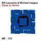 „Bill Laurance & Michael League, Close to Home.“ Abstrakte Illustration mit blauen und schwarzen quadratischen Formen.