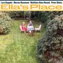 Text: Lars Duppler, Werner Neumann, Matthias Akeo Nowak, Peter Weiss, Ella’s Place. Zwei Personen im Garten an einem Tisch.