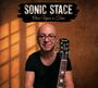 "Sonic Stace", "Once Upon a Time". Ein Mann mit Glatze, Brille, hält eine Gitarre vor einem warmen, texturierten Hintergrund.