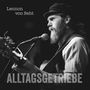 Text: "Lennon von Seht" und "ALLTAGSGETRIEBE". Schwarz-weiß Aufnahme eines bärtigen Mannes mit Gitarre am Mikrofon.
