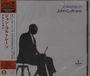 „Ascension John Coltrane“ steht oben rechts. Links vertikal: Japanische Schriftzeichen. Silhouette eines Mannes mit Saxophon.