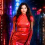 „JOYCE JONATHAN“ und „DE JUSTESSE“ stehen vertikal. Frau im roten Outfit vor neonbeleuchtetem Stadthintergrund.