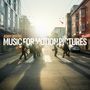 "Adam Gibbons - Music for Motion Pictures". Menschen überqueren einen Zebrastreifen in einer städtischen Umgebung bei Sonnenuntergang.