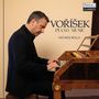 "VOŘÍŠEK PIANO MUSIC, MICHELE BOLLA" oben rechts "PIANO CLASSICS" Logo. Ein Mann spielt ein Klavier in einem Raum.
