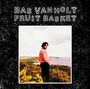 "Bas Van Holt Fruit Basket." Mann vor Küstenlandschaft mit gelben Blumen, schwarzer Rahmenhintergrund.