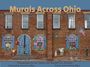 „Murals Across Ohio“ in großen Buchstaben, darunter Wandgemälde auf rotem Backsteingebäude mit verschiedenen Szenen.