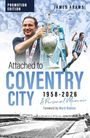 Text: "Attached to Coventry City 1958-2026 A Personal Memoir", "James Adams", "Foreword by Mark Robins". 

Illustration: Ein lächelnder Mann hält einen Pokal, Hintergrund zeigt jubelnde Fans und einen Fußballspieler.