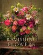 "Ravishing Flowers" mit üppigem Blumenarrangement in kräftigen Farben, darunter Lilien und Rosen, auf rustikalem Tisch.