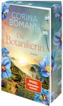 Buchtitel: "Die Botanikerin" von Corina Bomann. Naturillustration mit blauen Blumen und einer Berglandschaft im Sonnenaufgang.