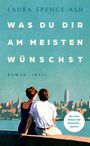 Titel: "Was du dir am meisten wünschst" von Laura Spence-Ash. Zwei Personen sitzen am Wasser mit Skyline im Hintergrund.