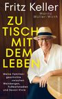 Cover von "Zu Tisch mit dem Leben" von Fritz Keller. Ein Mann mit Hut und Brille lächelt, sitzt an einem Holztisch.