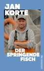 Text: "JAN KORTE DER SPRINGENDE FISCH". Ein Mann in orangefarbener Kleidung mit grauem Kapuzenpullover und Baseballkappe. Hintergrund mit Rettungsring und Netz.