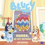„BLÜEY“, „HURRA, ES IST OSTERN!“, „MIT KLAPPEN“. Zwei Hunde vor einer Tür, fröhlich gestikulierend.