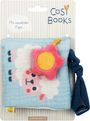 "Mit rasselnder Figur" steht auf einer Illustration mit einem weichen Buch. Ein Schaf und eine rosa Blume sind abgebildet.