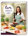 „Emmi kocht einfach mediterran“, „75 Rezepte für sonnigen Genuss – jeden Tag“. Eine Frau kocht in einer modernen Küche.
